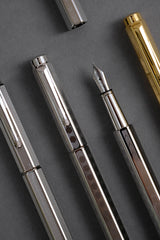 Caran d'Ache Ecridor Milanese Mesh, Chevron, and Heritage fountain pens on a gray background.