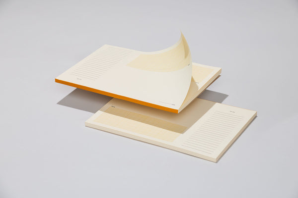 A desk pad with orange binding designed for easy tear-off sheets.