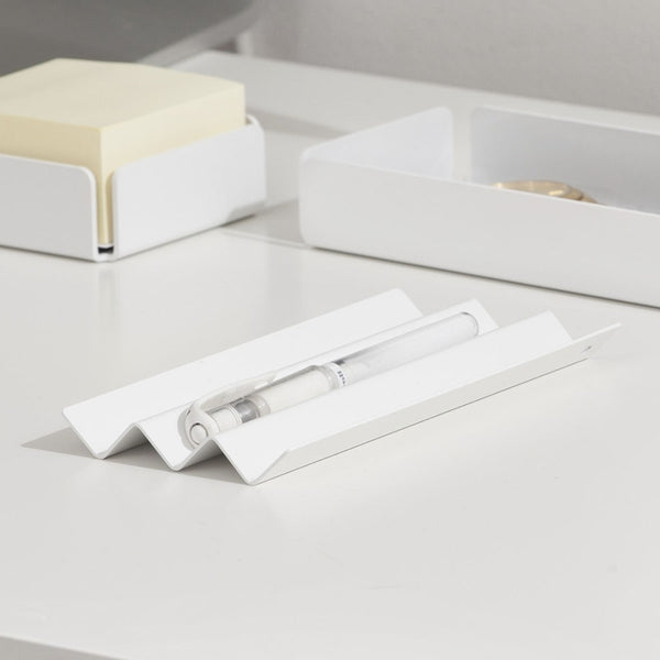 A white steel NAKA pen holder with a white pen placed on it.