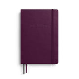 The front cover of a notebook with the “Bullet Journal” inscription and three fabric ribbon bookmarks.