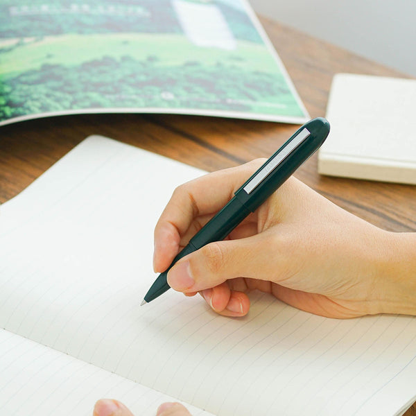 A green Bullet ballpoint pen held in hand.