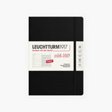 An 18-month calendar in English with a black hard cover, secured with an elastic band.
