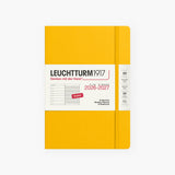 An 18-month calendar in English with a orange hard cover, secured with an elastic band.