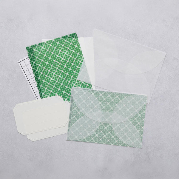 A letter-writing set with envelopes made of semi-transparent paper, decorative sheets for concealing the content of the letter in green, and address stickers.