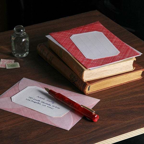 A letter-writing set with envelopes made of semi-transparent paper, decorative sheets for concealing the content of the letter in red, and address stickers.