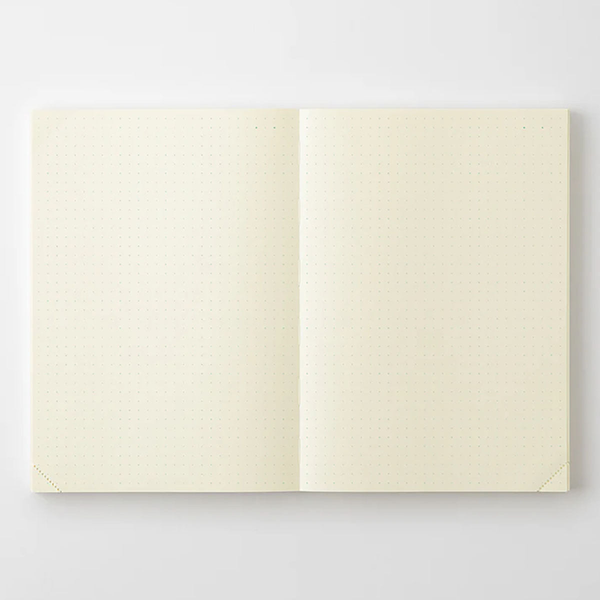 Otwarty na płasko notatnik MD Product Journal Codex A5 z zadrukiem w zielone kropki.