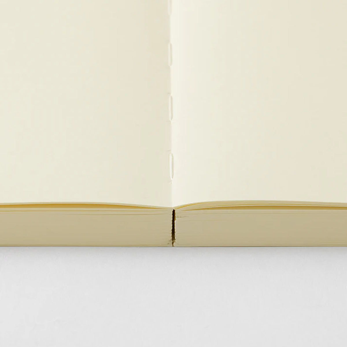 Otwarty na płasko notatnik MD Product Journal Codex A5 gładki w środku.