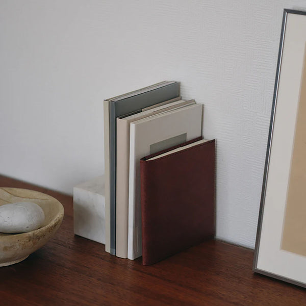 Several books standing on a wooden desk.