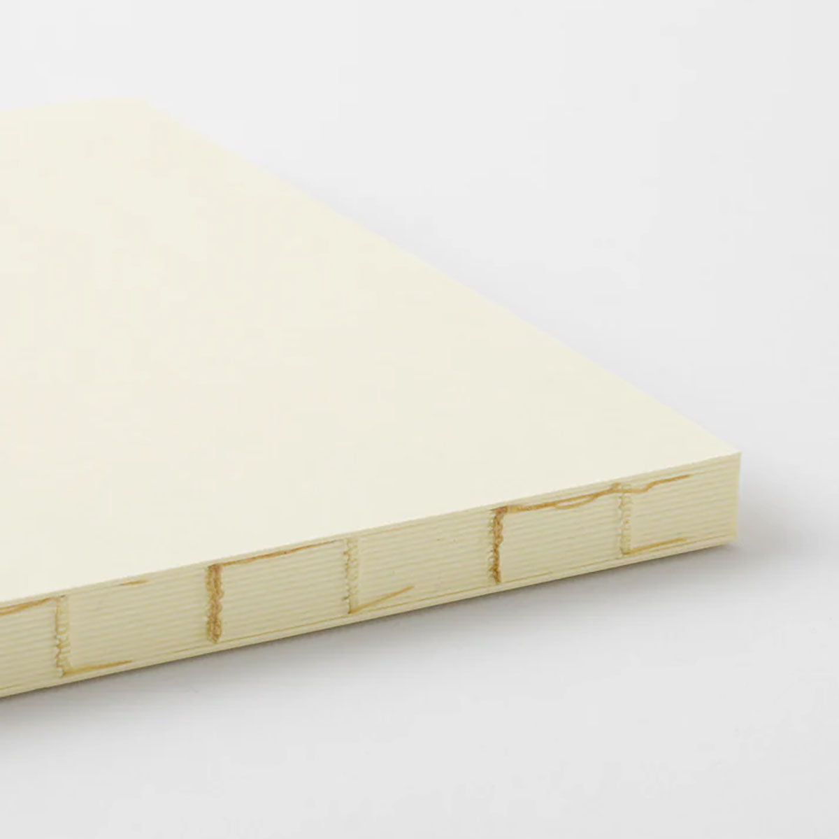 Surowy grzbiet szyty nićmi notatnika Midori.