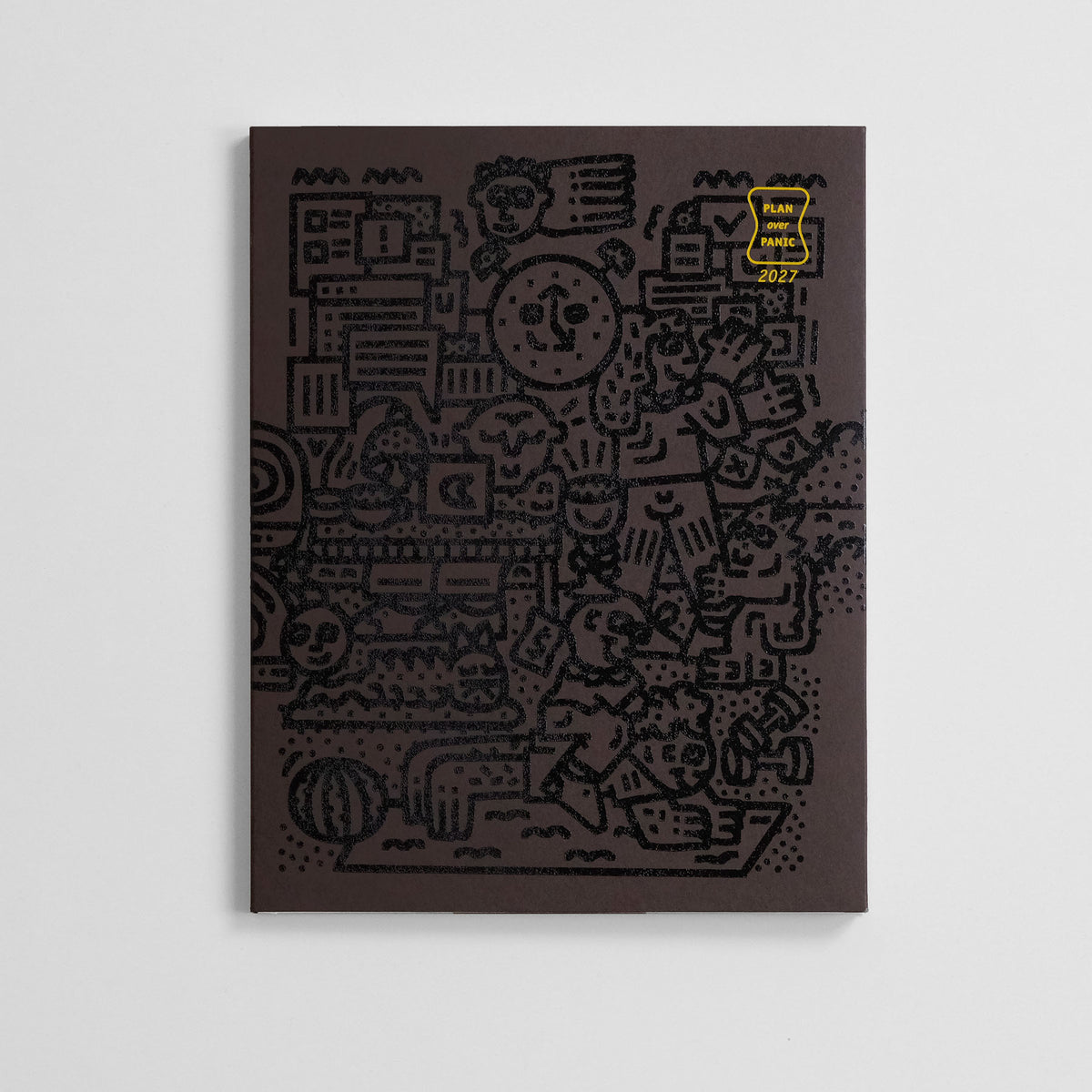 Brązowy kalendarz z czarną grafiką od Tommy'ego Pieñczaka.