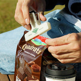 A cream plastic paper clip with a white logo, used to seal a snack bag.