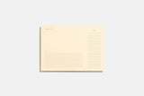A desk pad with tear-off sheets printed with lines, a fine grid, and blank space for notes.