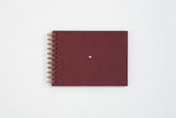 Canvas photo album in burgundy color. Finished with a copper spiral and a small heart in the center.