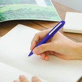 A blue Bullet ballpoint pen held in hand.