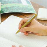 A khaki Bullet ballpoint pen held in hand.