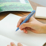 A blue Bullet ballpoint pen held in hand.