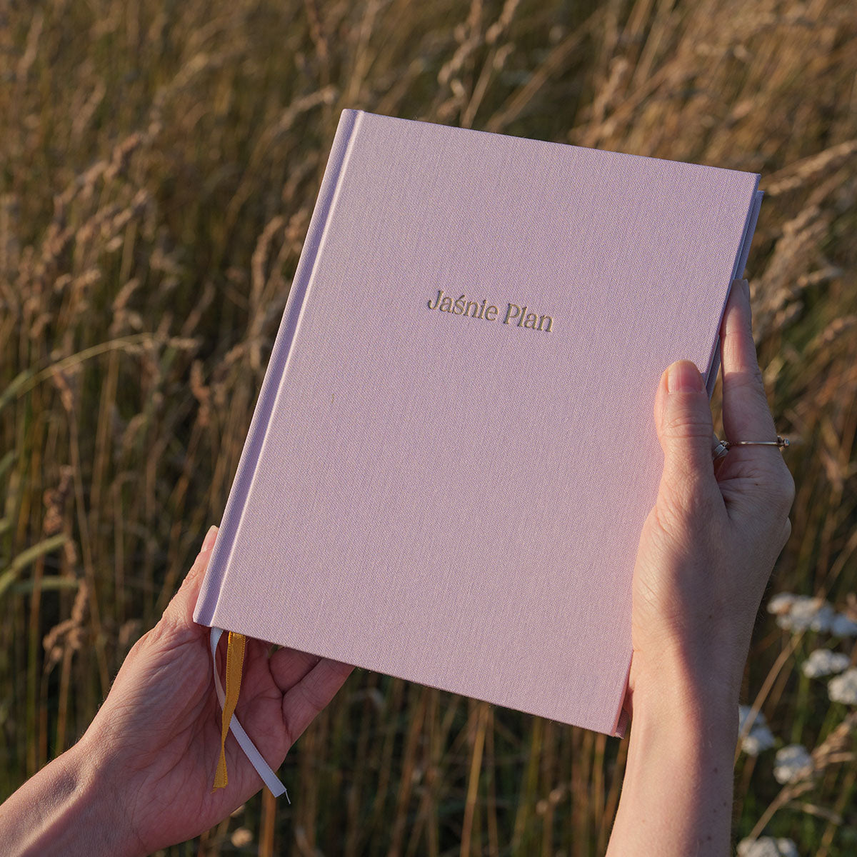Planner Jaśnie Plan w kolorze lilac na tle łąki.