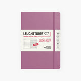 An 18-month calendar in English with a pink hard cover, secured with an elastic band.