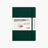 An 18-month calendar in English with a green hard cover, secured with an elastic band.