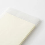 A translucent paper dust jacket on a cream-colored MD Product notebook.