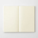 A cream-colored MD Product series notebook with green dots, opened flat.