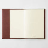 An open chocolate-colored paper cover in a A5 format with a notebook inside.