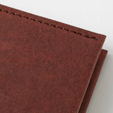 Corner of a chocolate-colored MD Product cover by the Midori brand.