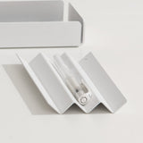A white steel NAKA pen holder with a white pen placed on it.
