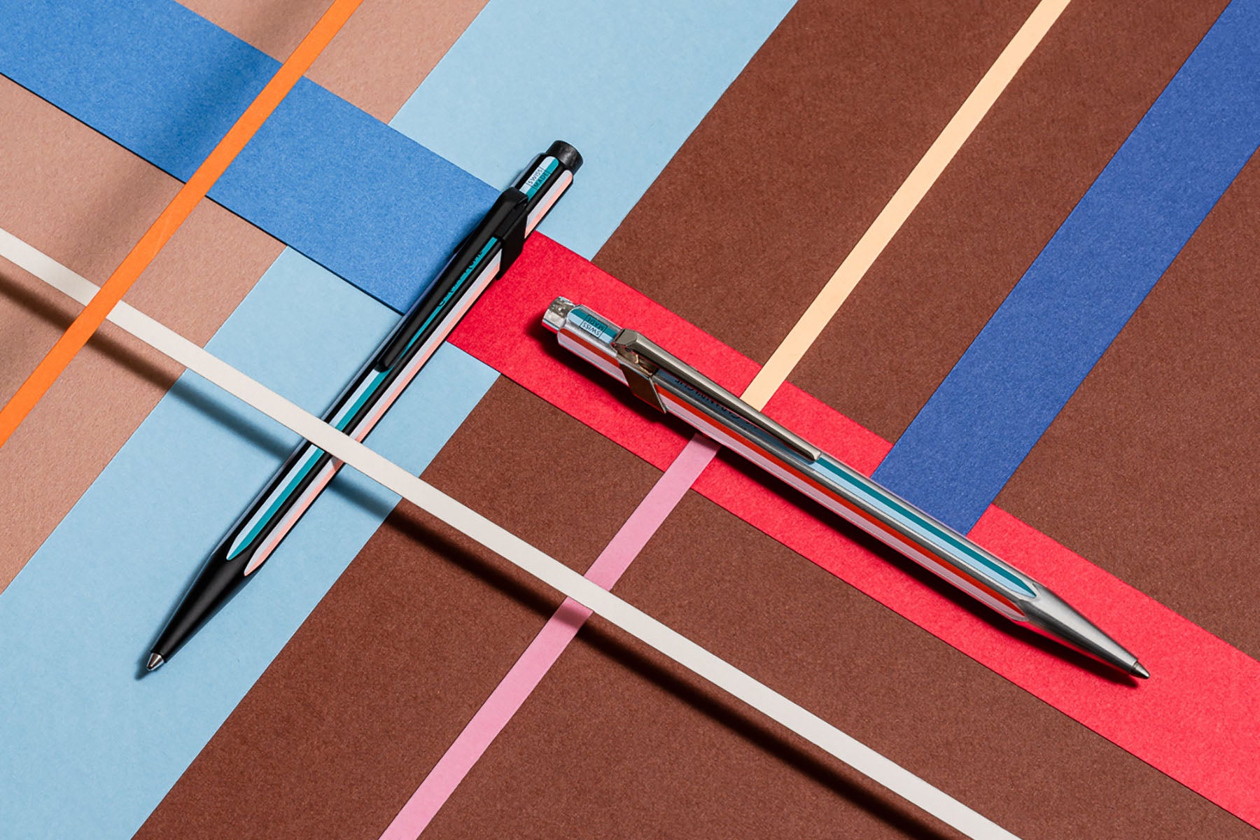 Czarny i srebrny długopis w kolorowe paski z kolekcji Caran d'Ache x Paul Smith.
