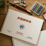 A sketchbook with the Penco brand name on the cover along with other drawing accessories.