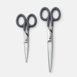 Comparison of two sizes of scissors with gray handles.